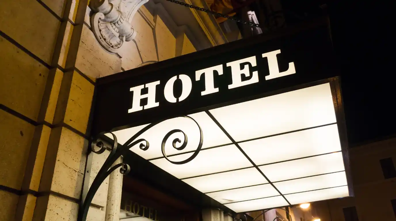 Entrée d'hôtel de nuit mise en valeur par un caisson lumineux